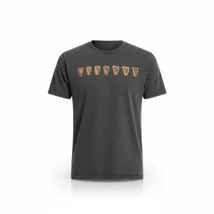 The Guinness Black Evolution Harp Premium Tee features a row of seven tan shield emblems across the chest.