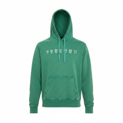 The Guinness Evolution Harp Green Hoodie features a front pocket and shield-shaped chest designs, offering a vintage look inspired by the classic Guinness style.
