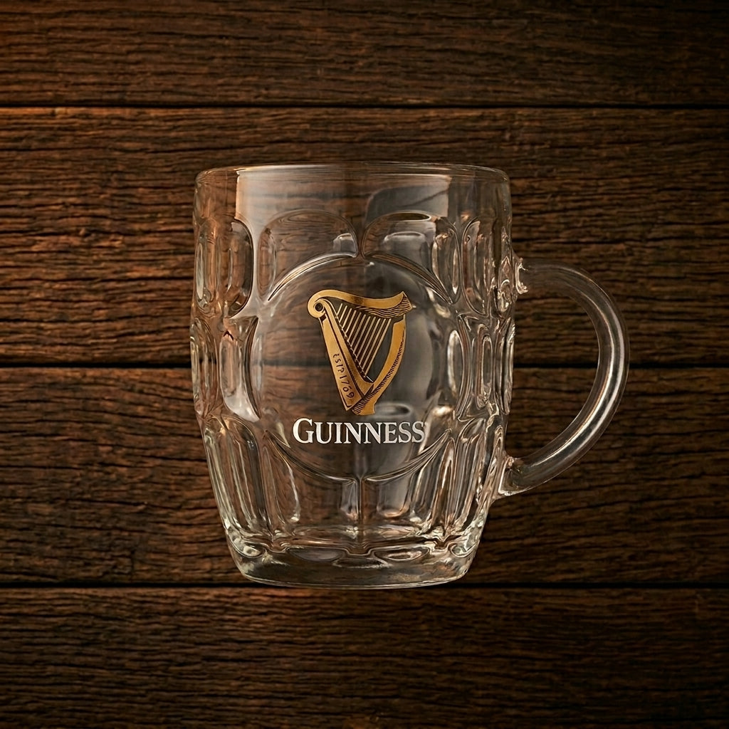 The Guinness Gold Harp Dimple Glass Mug – 20 oz Tankard from Guinness Webstore US, with its iconic logo and harp emblem, is a must-have for any Irish pub glass collection.