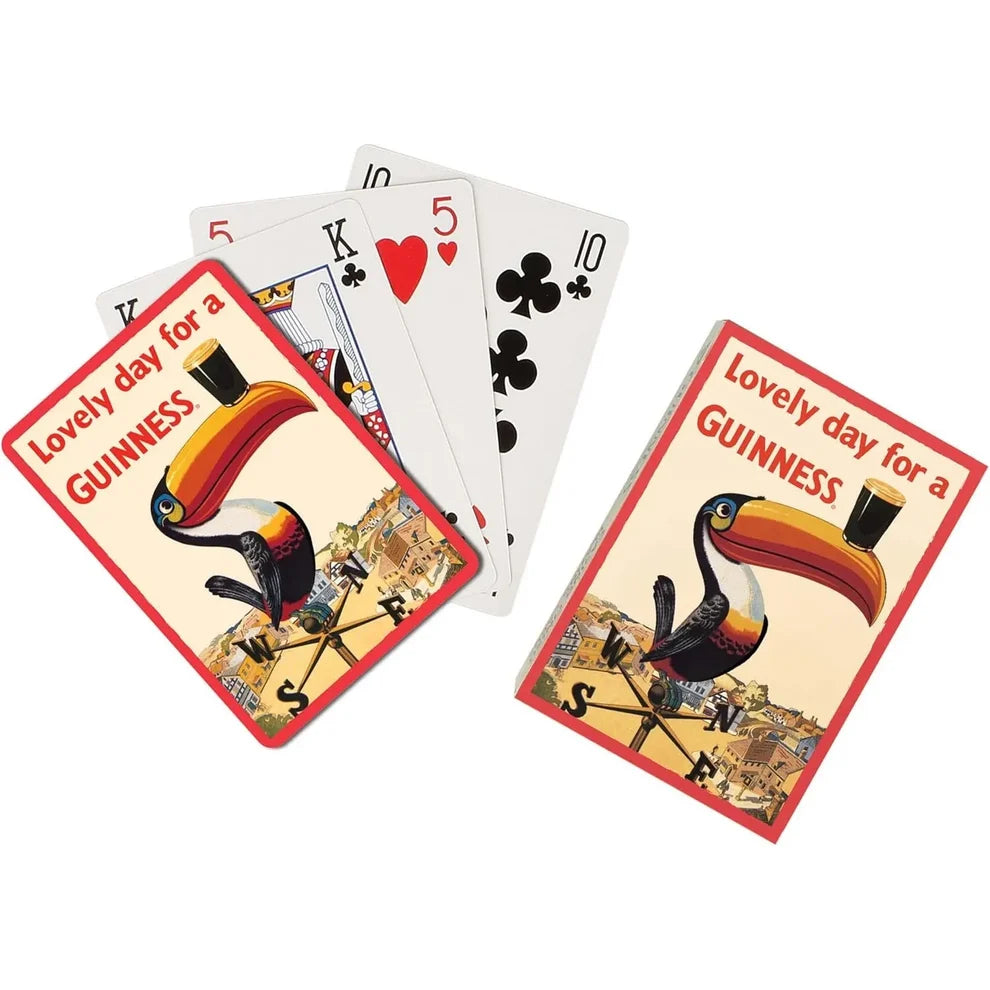 A Guinness Vintage Toucan Playing Cards – 54-Card Deck featuring a vintage toucan illustration and the text, “Lovely day for a GUINNESS,” displayed as a deck with a few loose cards.