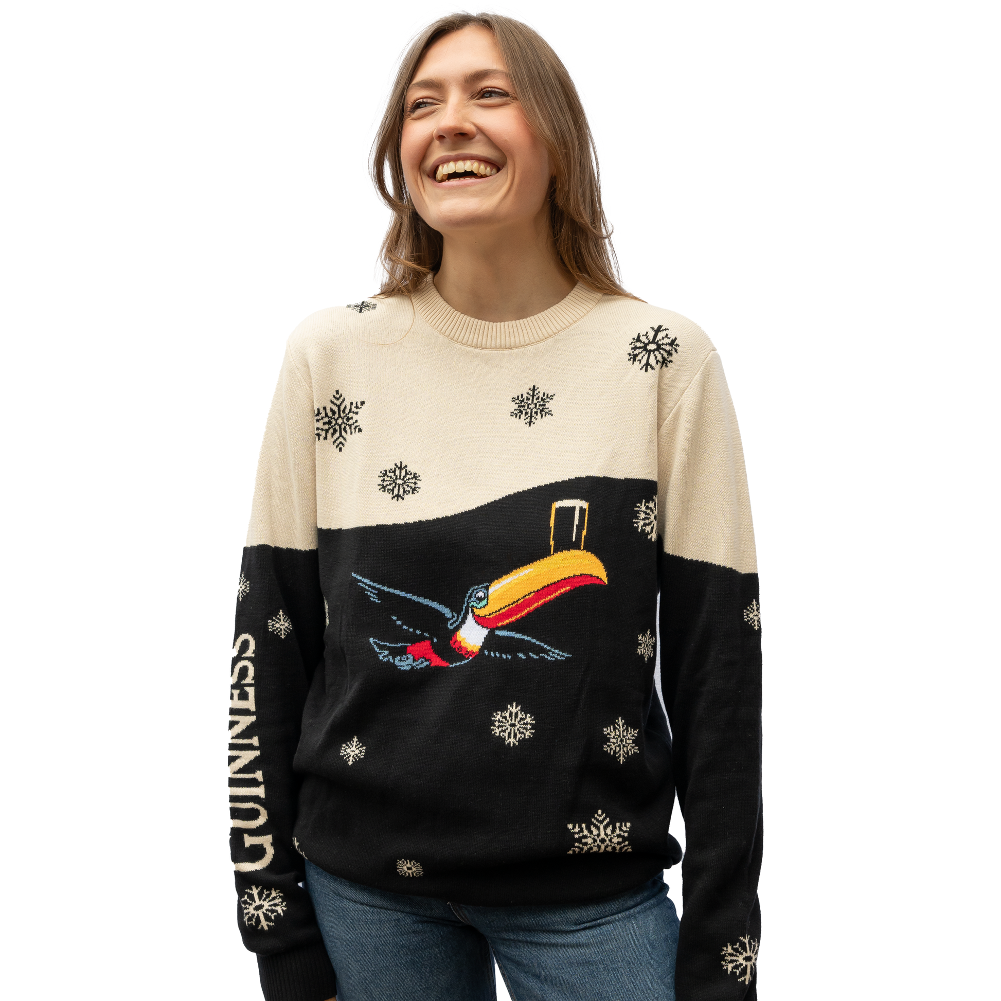 A person smiling, wearing the Guinness Holiday Black and Cream Toucan Sweater from Guinness Webstore US, featuring a playful toucan and delicate snowflakes.