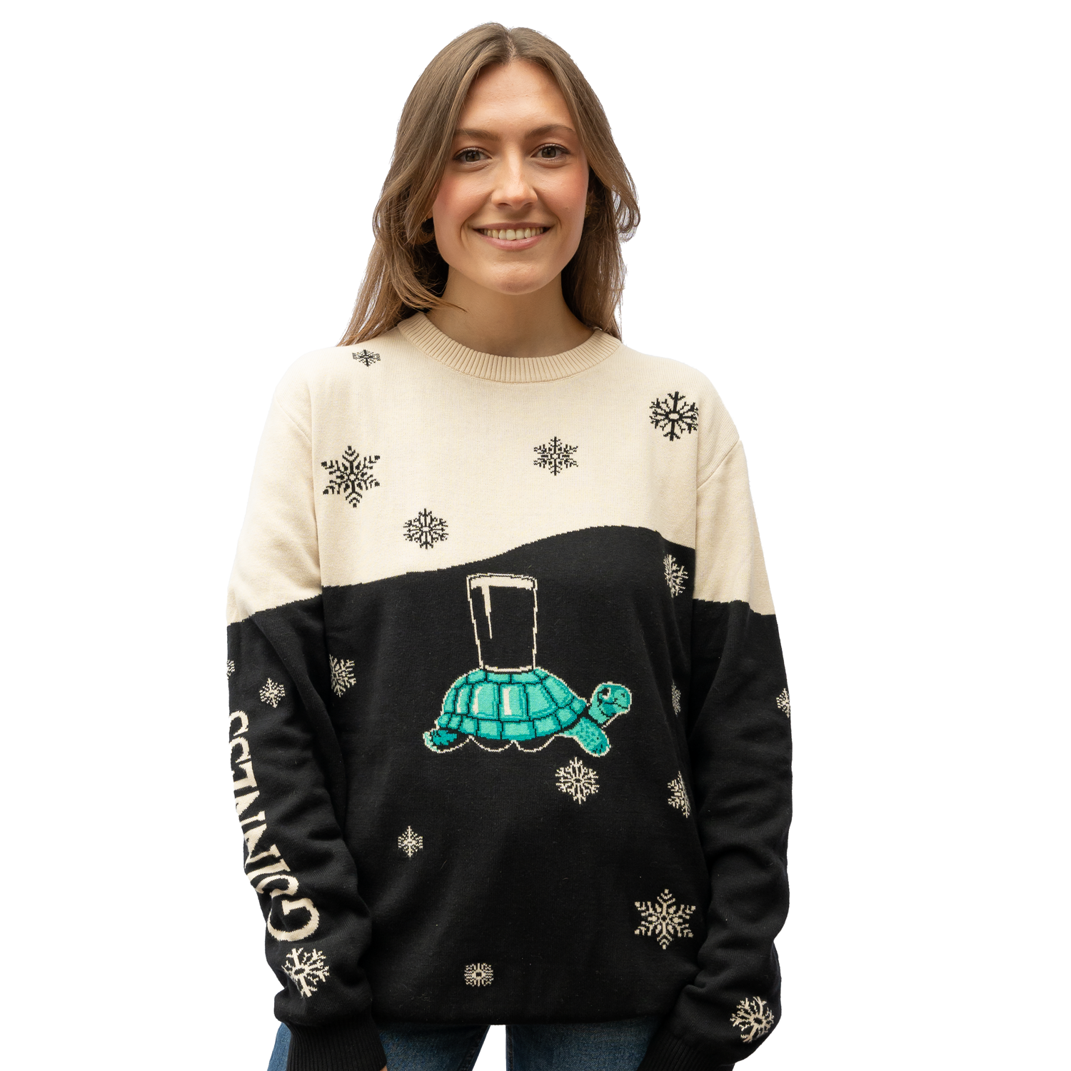 A person wearing a Guinness Holiday Black and Cream Tortoise Sweater, featuring snowflake patterns and a playful tortoise design, similar to those found at the Guinness Webstore US, holds a glass perched on its back.