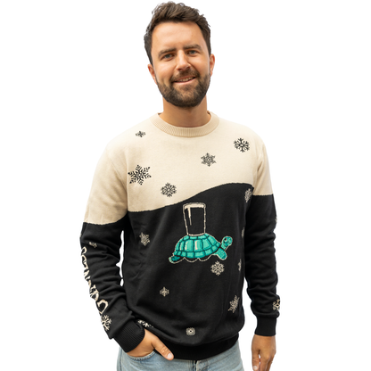 A person wearing the Guinness Holiday Black and Cream Tortoise Sweater from the Guinness Webstore US stands against a plain background.