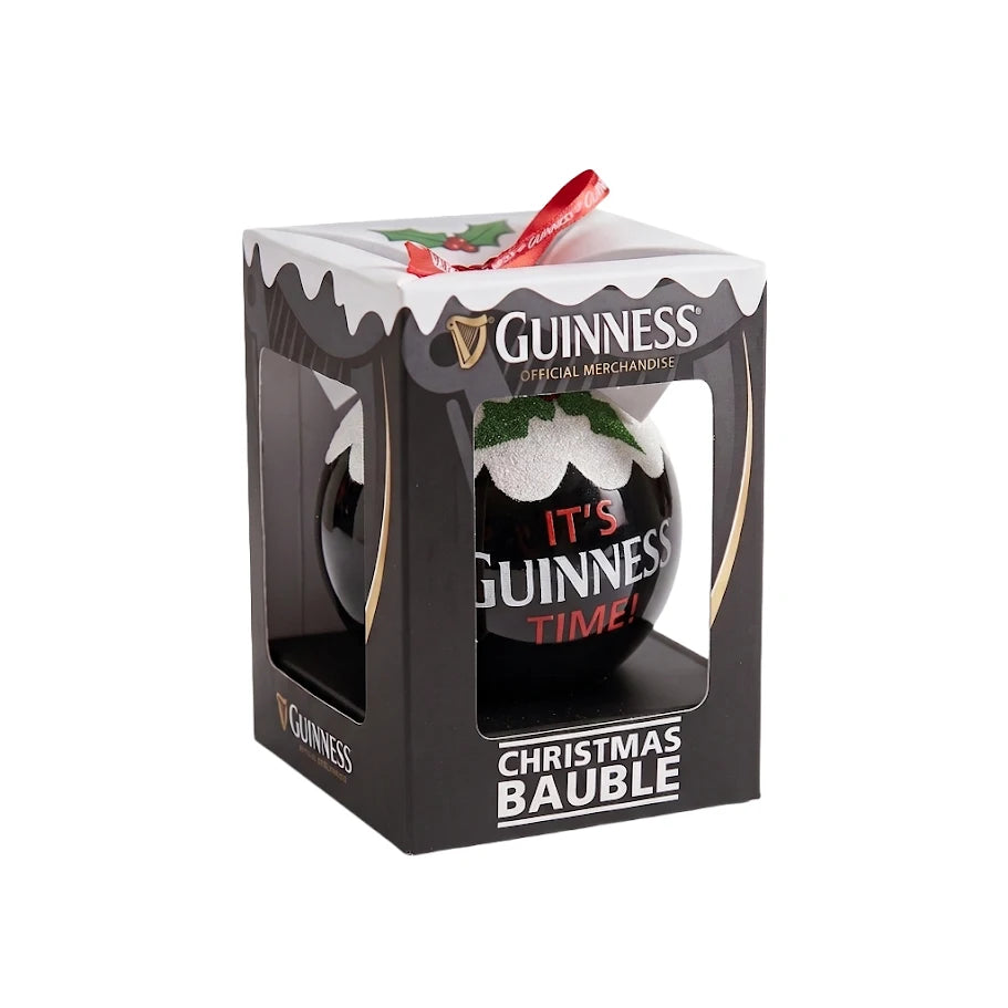 A boxed Guinness Christmas Holiday Pudding Bauble with “It’s Guinness Time!” printed on it, featuring a festive holly and snow design, and finished with a red hanging ribbon—perfect as a holiday tree decoration.