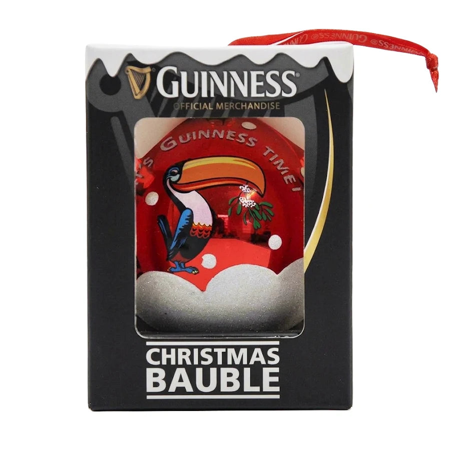 Celebrate the holidays with the Guinness Toucan Glass Bauble, a festive Christmas tree decoration from Guinness. This charming bauble features the iconic Guinness Toucan holding holly on a snowy red background, complete with “It’s Guinness Time” text for added holiday cheer. Comes beautifully boxed for gifting or display.